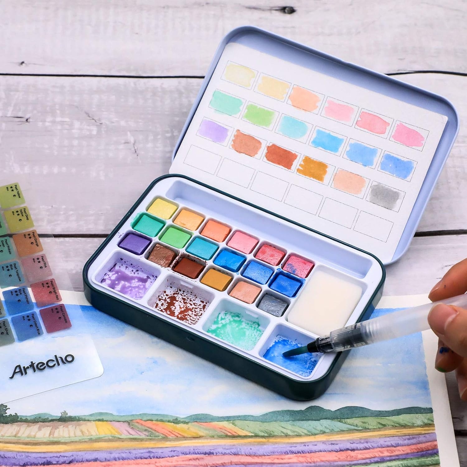 image:imageArtecho 24 Colors Watercolor Paint Set Portable Travel Tin Box with Brush  Watercolor Paper Color Chart amp Sponge Included  Lightweight Metal Case  Creative Gift for Artists Students Beginners18 metallic colors